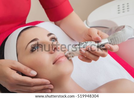 Rejuvenating facial treatment. Model getting lifting therapy massage in a beauty SPA salon. Exfoliation, Rejuvenation And Hydratation. Model and Doctor. Cosmetology.