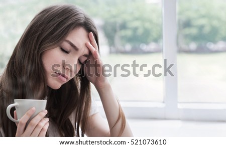 Young sad woman with cup of coffee or tea. Stress, depression, illness concept.