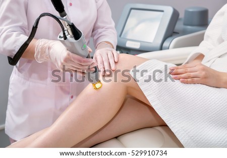 Hair removal cosmetology procedure from a therapist at cosmetic beauty spa clinic. Laser epilation and cosmetology.