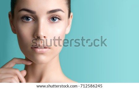 Beautiful young woman with clean perfect skin. Portrait of beauty model with natural nude make up and long eyelashes. Spa, skincare and wellness. Close up, background, copyspace.