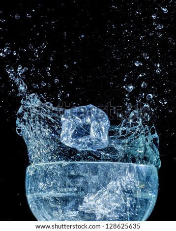 Ice cube fall into the water wave drops splash dynamic motion glass background isolated black
