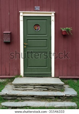 Green door, red woody wall and stone stairs