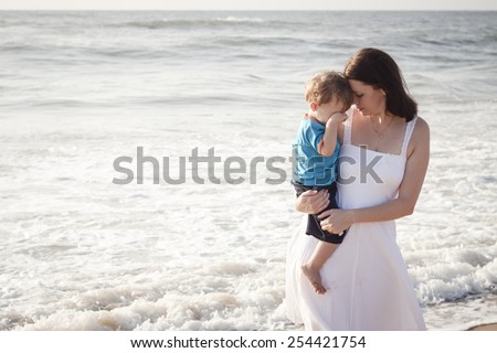 Young mom with son playing at the beach