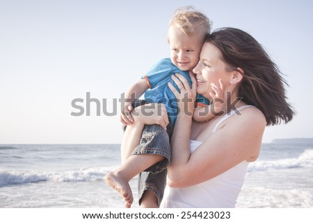 Young mom with son playing at the beach