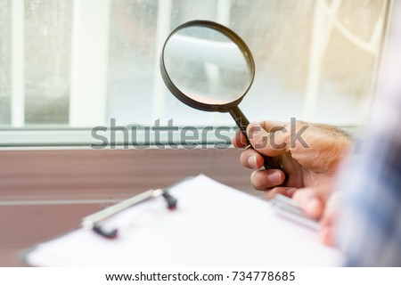 Inspection checklist review material property. Consultant house inspector holding Magnifying glass check material of property real estate for client before receive new house from agent.