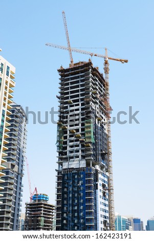 DUBAI, UAE - SEPTEMBER 12: The construction of new skyscraper in Dubai city on September 12, 2013 in Dubai, UAE. In the city of artificial channel length of 3 kilometers along the Persian Gulf.