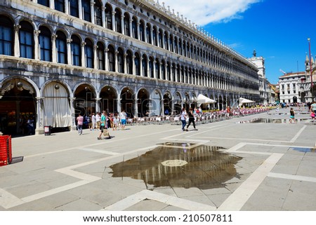 VENICE, ITALY - JUNE 16: The flooding of St Mark\'s Square and tourists on June 16, 2014 in Venice, Italy. More then 46 mln tourists is expected to visit Italy in year 2014.