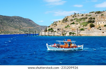 SPINALONGA, GREECE - MAY 14: The motor yacht with tourists is near Spinalonga island on May 14, 2014 in Spinalonga, Greece. Up to 16 mln tourists is expected to visit Greece in year 2014.