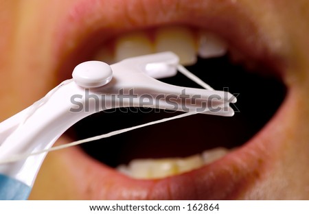 Person Flossing Teeth