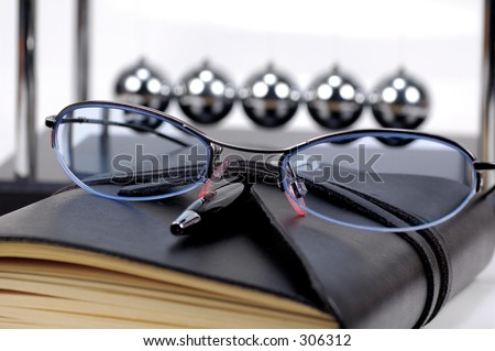 Eyeglasses and a Journal on a Desk.