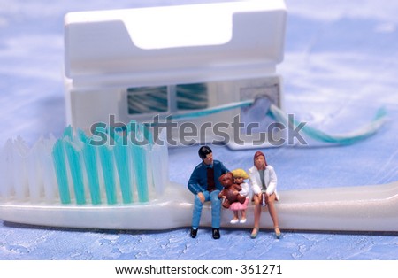 Miniature People Sitting on a Toothbrush.  Family or Pediatric Dental Concept.