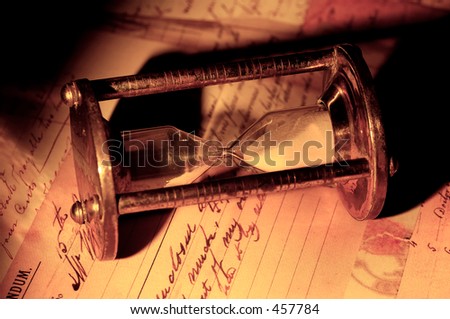 Photo of a Hourglass and Old Letters With Creative Lighting.