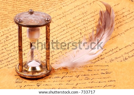 Hourglass with a feather and Parchments