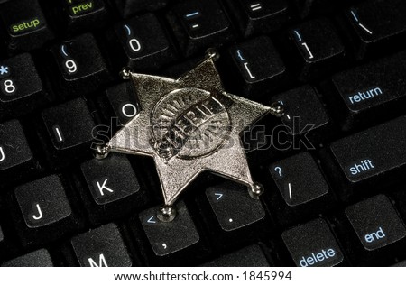 Photo of a Computer Keyboard and a Sherifes Badge - Internet Security Concept