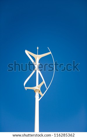 Vertical axis wind turbine against a clear deep blue sky