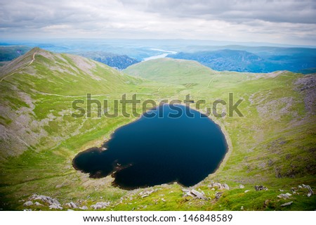 Red Tarn (a small lake) surrounded by mountains in the Lake District National Park, Cumbria, England