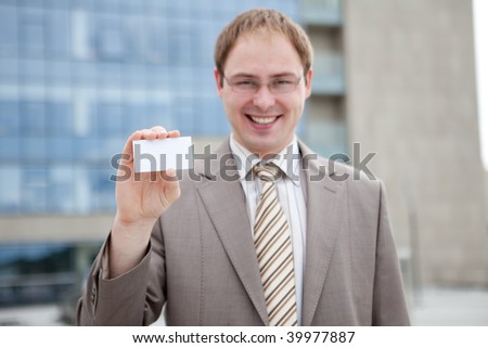 Business man handing a blank business card (outdoor the office)