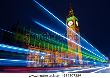 Traffic through London Big Ben one of the most prominent symbols of both London and England as shown at night along with the lights of the cars and buses passing by Traffic through London Big Ben one of the most prominent symbols of both London and England as shown at night along with the lights of the cars and buses passing by