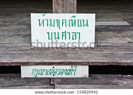 Warning in Thai language. Do not light a candle on the hall