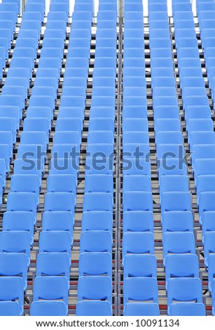 Rows of blue plastic chairs with no occupants