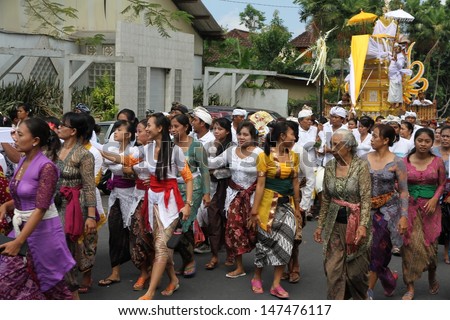 DENPASAR, INDONESIA - MAY 12: Balinese village women parade in front of the funeral pyre as they walk to a Ngaben or cremation ceremony  in Ubud, Denpasar, Bali, Indonesia on May 12, 2013.