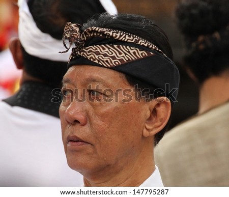 DENPASAR, INDONESIA - MAY 13:  A Balinese man at a Royal Ngaben or cremation ceremony wearing traditional head dress in Ubud, Denpasar, Bali, Indonesia on May 13, 2013.
