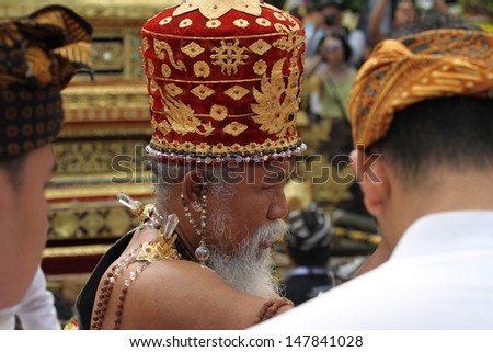 DENPASAR, INDONESIA - MAY 13: A Balinese priest or holy man blessing people outside the Royal temple prior to a Royal Ngaben ceremony taking place in Ubud, Denpasar, Bali, Indonesia on May 13, 2013.