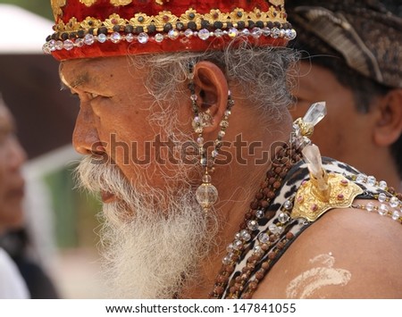 DENPASAR, INDONESIA - MAY 13: A Balinese priest or holy man blessing people outside the Royal temple prior to a Royal Ngaben ceremony taking place in Ubud, Denpasar, Bali, Indonesia on May 13, 2013.