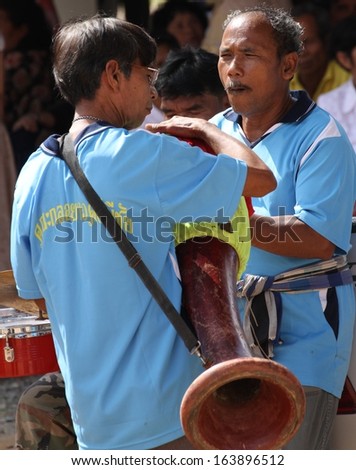 NAKHON SI THAMMARAT, THAILAND, NOVEMBER 2: Two musicians at a traditional Buddhist ceremony, Kathin, held at Wat Khao Phra Thong, Nakhon Si Thammarat, Thailand on the 2nd November, 2013.
