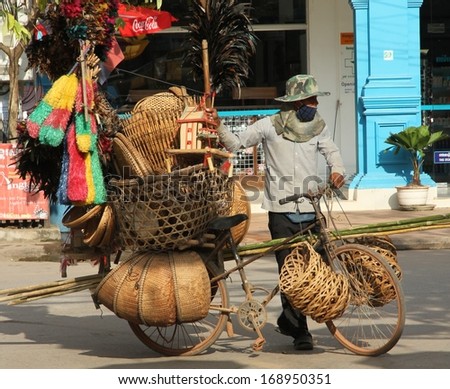 SIEM REAP, CAMBODIA - NOVEMBER 19th: A traditional Cambodian vendor with his push bike loaded up with woven basketware and brooms in the street of Siem Reap, Cambodia on the 19th November, 2013.