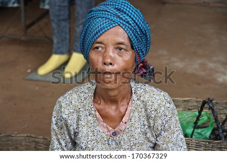 SIEM REAP, CAMBODIA - NOVEMBER 23: A closeup of a Cambodian woman sitting with her goods for sale at a local market near Siem Reap, Cambodia on the 23rd November, 2013.