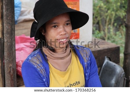 SIEM REAP, CAMBODIA - NOVEMBER 23: A closeup of a Cambodian woman sitting with her goods for sale at a local market near Siem Reap, Cambodia on the 23rd November, 2013.