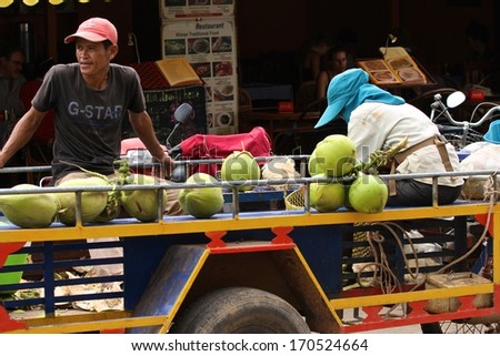 SIEM REAP, CAMBODIA - NOVEMBER 27: Cambodian street food hawkers selling green coconuts from a cart in Siem Reap, Cambodia.