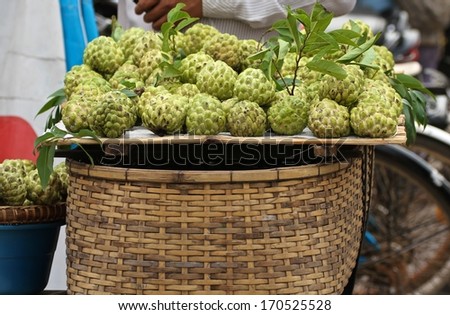 A hand woven basket full of custard apples for sale in the street of Siem Reap, Cambodia.