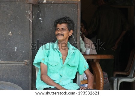 KANDY, SRI LANKA - FEBRUARY 18: A Sri Lankan man sitting outside a shop in a country town outside of Kandy on the 18th February, 2014.