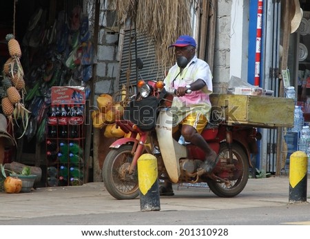 DAMBULLA, SRI LANKA - FEBRUARY 15: A common sight of a man, his motor bike outside a shop in a country town near Dambulla, Sri Lanka on the 15th February, 2014.