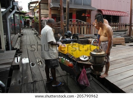 GEORGETOWN, MALAYSIA - MAY 29: A traditional food vendor and customers on the Clan Jetties at Georgetown, Malaysia on the 29th May, 2014.