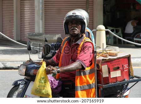 GEORGETOWN, MAYLASIA - MAY 30: The local post man delivering mail in the streets of Georgetown, Malaysia on the 30th May, 2014.