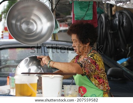 GEORGE TOWN, MALAYSIA - MAY 30: A local Malay woman cooking at a street stall in George Town, Malaysia on the 30th May, 2014.