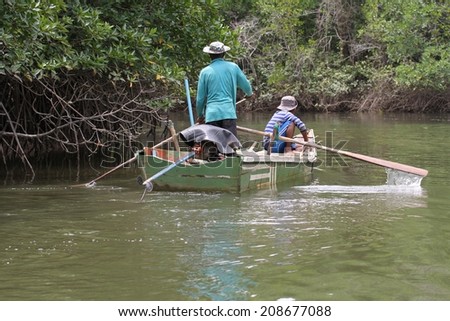 BANGKOK, THAILAND - MAY 14: Local Thai fishermen in their canoe amongst the mangrove forest near Tabla Mu Pier on the Khao Lak coastline, Bangkok, Thailand on the 14th May, 2014.