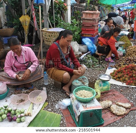 LUANG PRABANG, LAOS - AUGUST 15: Local hill tribe women selling their fresh food produce at the local market in Luang Prabang, Laos on the 15th August, 2014.