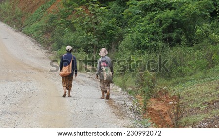 LUANG PRABANG, LAOS - AUGUST 16: Two local hill tribe women walking along a countryside road in Luang Prabang, Laos on 16th August 2014