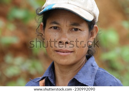 LUANG PRABANG, LAOS - AUGUST 16: A closeup of a local hill tribe woman walking on a countryside road collecting firewood in Luang Prabang, Laos on 16th August 2014