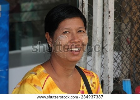MAE SOT, THAILAND - SEPTEMBER 2:\
A local woman with thanaka on her face sitting on the side of the road in the border town of Mae Sot, Thailand on the 2nd September, 2014.