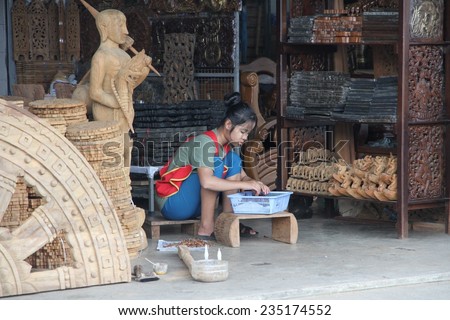 MAE SOT, THAILAND - SEPTEMBER 2: A young hill tribe woman with thanaka on her face working in a shop in the town of Mae Sot, Thailand on the 2nd September, 2014.