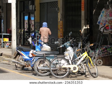 KANCHANABURI, THAILAND - SEPTEMBER 3: Parked motor bikes in the main road in the town of Kanchanaburi, Thailand on the 3rd September, 2014.