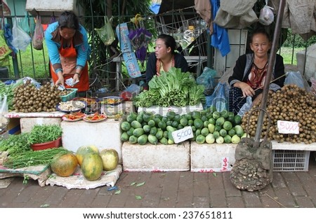VIENTIANE, LAOS - AUGUST 6: Local women selling fresh vegetables and fruit at the produce market in Vientiane, Laos on the 6th August, 2014.
