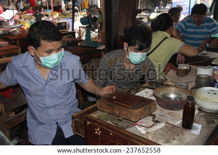 VIENTIANE, LAOS - AUGUST 6: Jewelry makers at work in the local market place of Vientiane, Laos on the 6th August, 2014.