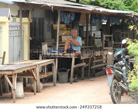 LUANG PRABANG, LAOS - AUGUST 14: A local Laotian man sitting in the shade of a lean to in the Unesco town of Luang Prabang, Laos on the 14th August, 2014.