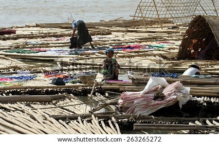 MANDALAY, MYANMAR - NOVEMBER 7:\
A shanty town built on bamboo poles tied together with locals going about their daily lives on the riverbank of the town of Mandalay, Myanmar on the 7th November 2012.